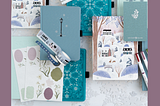 stylized flatlay of archer and olive notebooks, stickers, washi tape, and pens in the 2025 winter collection