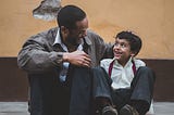 An African father smiling at his son.