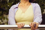 woman standing holding onto a rail