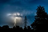 A lightning flash next to a power line.