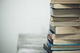 A stack of books on a wooden table