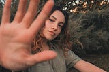 Girl pointing her whole open palm towards the camera