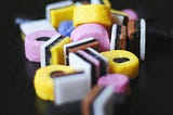 Close-up of colorful licorice Allsorts on a black background