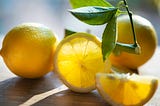 Close-up still life of lemon slices on a wooden table with light seeping through.