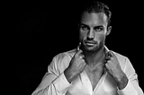 Black and white photo of a handsome man with a white shirt open at the top