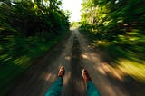 A man’s feet as he slips swiftly down a path in the woods