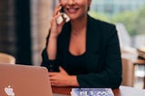 woman on a phone sitting at a desk