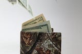 A wallet with money flying out of it.
