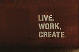 A mural with writings on it that says live work create