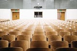 Empty auditorium with lots of chairs.