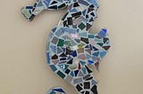 Photo of a seahorse mosaic, filled with blue and green glass tiles