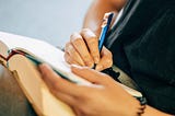 A person is writing in a book.