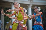 Indian women with different shades of skin performing a dance.