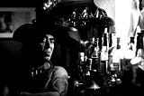 Black and white image of a Native American man sitting at a bar.