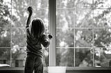 Little girl cleaning a window.