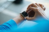 “A person wearing a smartwatch, symbolizing the integration of IoT in telemedicine. The smartwatch represents technology’s role in revolutionizing healthcare accessibility and efficiency.”