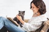 A beautiful woman with a cat and book