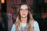 Portrait of a woman with glasses looking directly at the viewer.