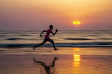 Man Running on Beach with Sunset in the background