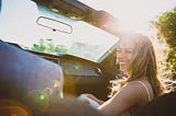 Young woman is laughing sitting in car