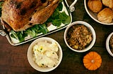 a Thanksgiving table with a turkey and side dishes.