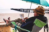 A man reading in a beachfront