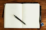 A blank diary, open, with a pen on it.