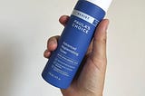 White capped, blue cylindrical bottle with writing reading Paula’s Choice-Resist Advanced Replenishing Anti-Aging Toner with Vitamins C & E, 118ml Ounce bottle