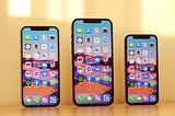 All three iPhone 12 models side by side on top of desk