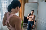 A women viewing her belly in the mirror