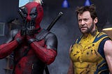 Deadpool with a look of shock on his face stands next to Wolverine who has more of a look of bewilderment in this still from Deadpool and Wolverine.