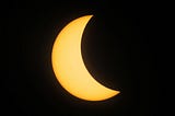 Sun’s light half blocked by the moon in solar eclipse.