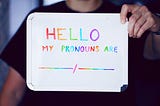 Person holding a sign “Hello My Pronouns Are” [BLANK]