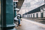 A man sitting on a bench with his head down