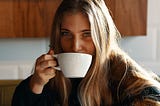 An everyday woman drinks from her mug of coffee