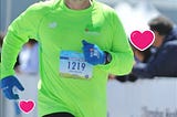 Picture of the author running a marathon with hearts to signify February.