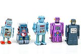 five mechanical toy robots in a line