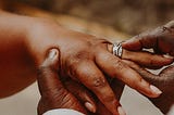 A Picture of a couple exchanging wedding rings