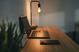 A laptop sitting neatly on a desk next to a phone turned face down.