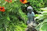 Boy on a Tortoise garden ornament in a garden