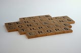 Scrabble game tiles arranged in five rows reading, “This sentence contains three errors.” Alt text to illustrate the importance of alt text.