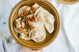 Dumplings on a plate which tragically haven’t been fried yet