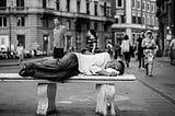 picture of homeless man lying on a bench