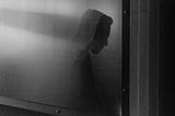 Black and white photo of a man’s silhouette looking down and to the right.