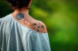 Woman’s tatoos on the neck and the right shoulder from behind