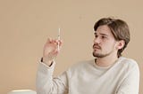 Man looking at syringe before injecting insulin