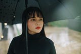 photo of woman holding black umbrella