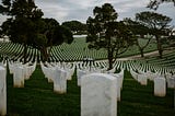 Image of a Veteran Cemetery showing a rolling hill of thousands of white headstones honoring our fallen heroes.