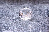 Picture of a clear gem on a bed of clear broken glass