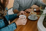 Couple holding hands and drinking coffee